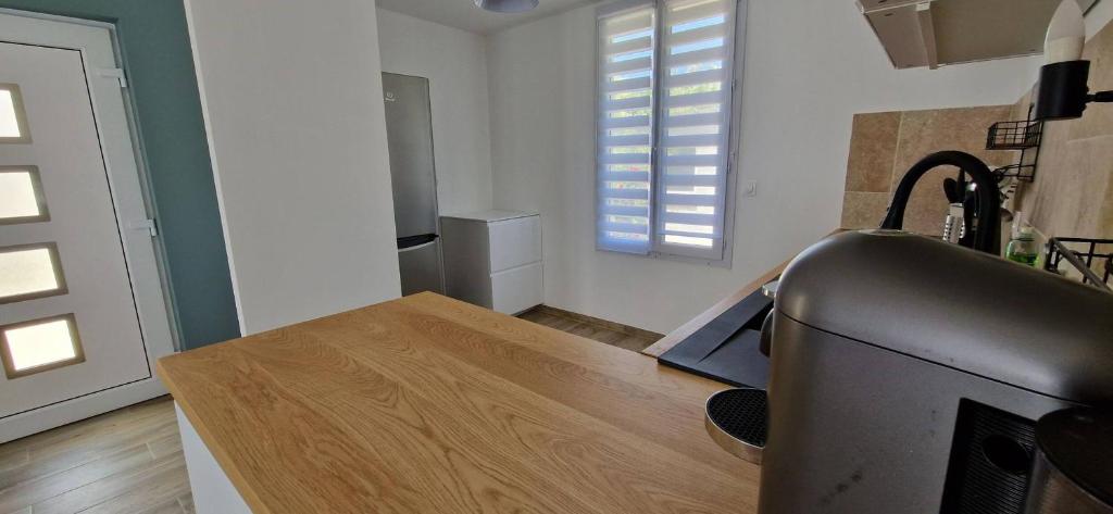 a kitchen with a tv and a wooden table at Maison 4 A 6 Personnes in Belleville-sur-Mer