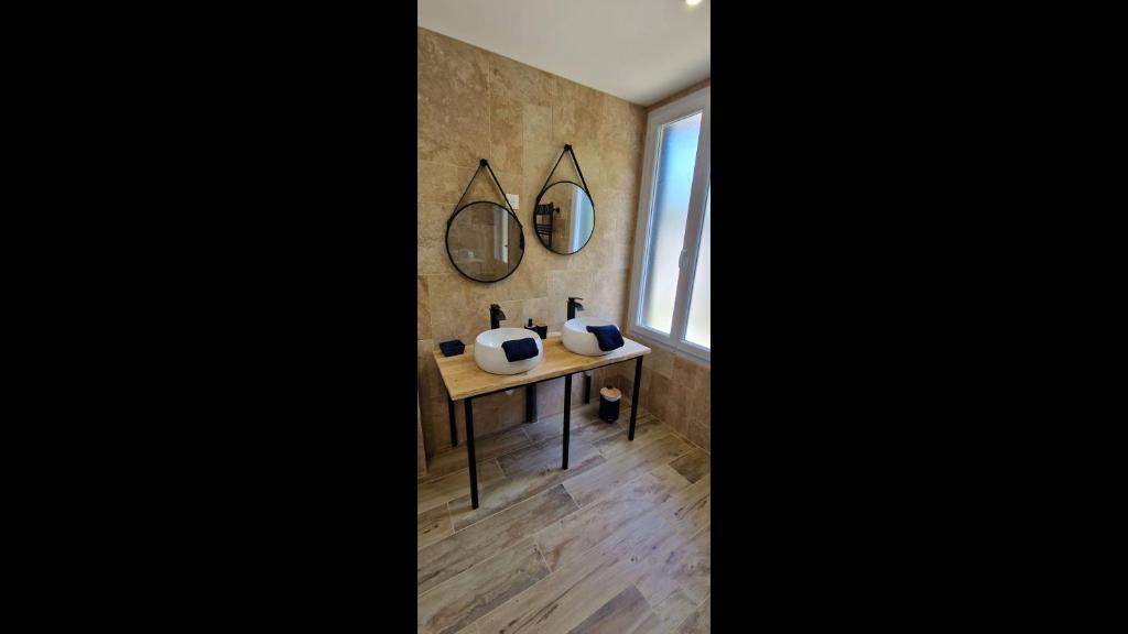 a bathroom with a table and two mirrors on the wall at Maison 4 A 6 Personnes in Belleville-sur-Mer