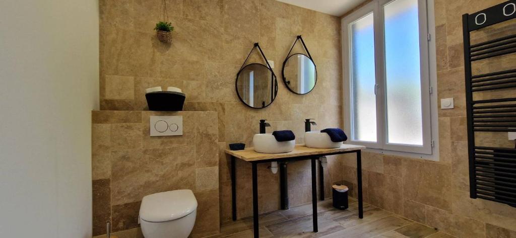 a bathroom with a toilet and two mirrors on the wall at Maison 4 A 6 Personnes in Belleville-sur-Mer