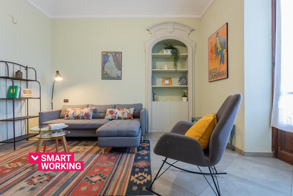 Casa Dora by Wonderful Italy في تورينو: غرفة معيشة مع أريكة وكرسي