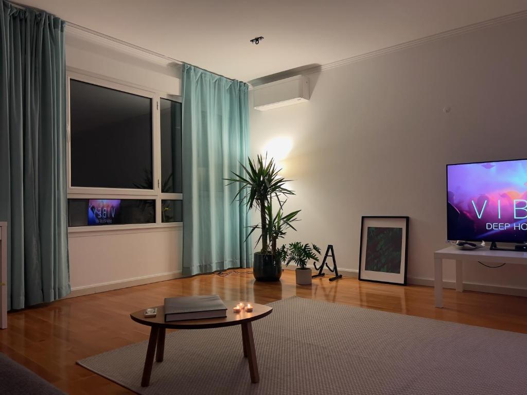 a living room with a tv and a table at Boutique Apartment - 2 Bedroom - Lisbon City Center in Lisbon