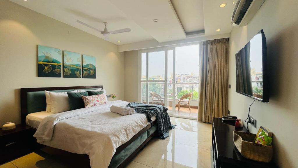 een slaapkamer met een groot bed en een groot raam bij ZEN Suites Gurgaon - LUXE Stays Collection in Gurgaon