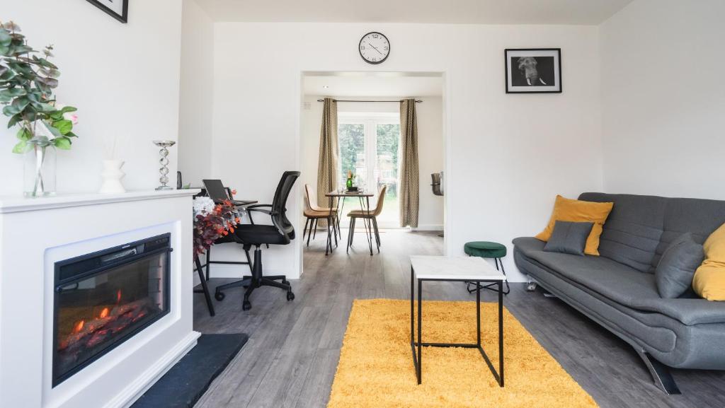 ein Wohnzimmer mit Couch und Kamin in der Unterkunft Comfy Spacious Home Near Preston City Centre - Sleeps 6 in Samlesbury