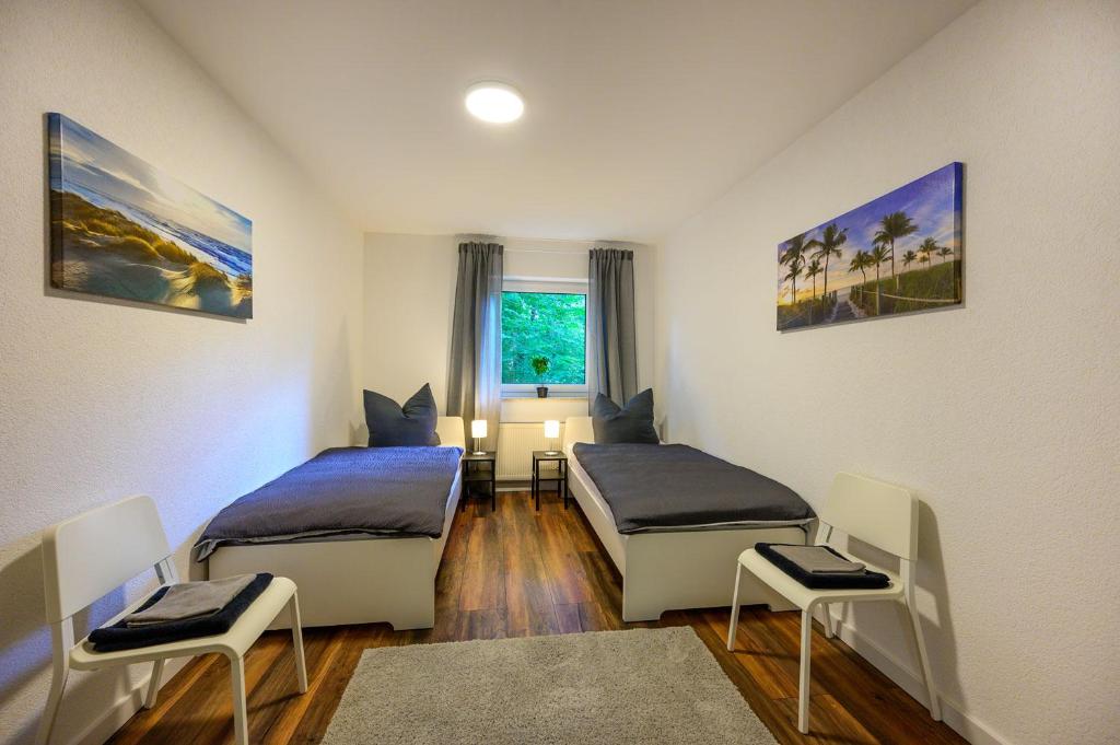 a room with two beds and a table and chairs at Nice Apartment in Marburg in Marburg an der Lahn