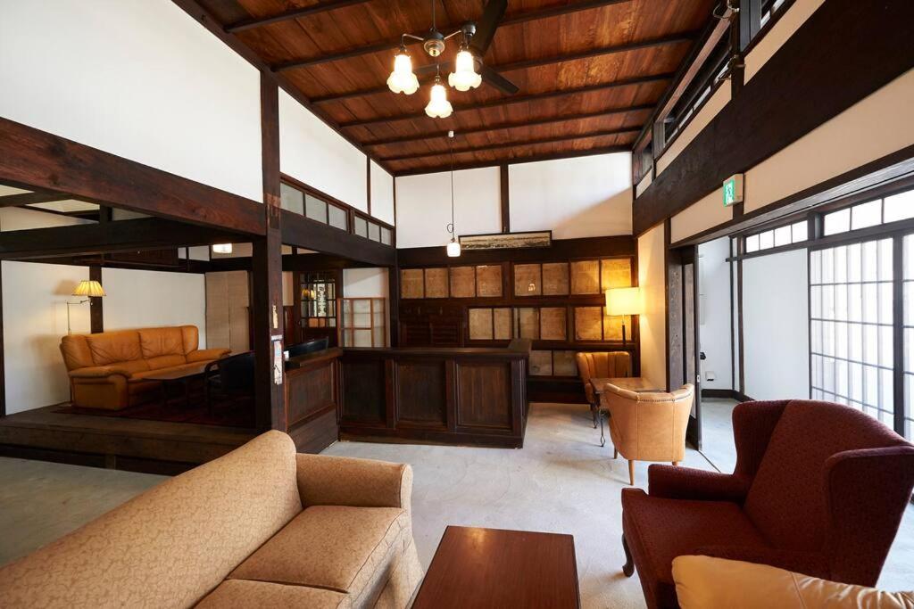 sala de estar con sofá, sillas y mesa en 庭の宿 帆や niwayado hoya, en Yaizu