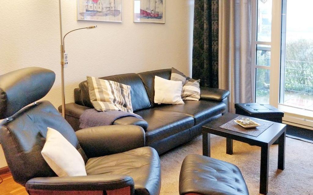 sala de estar con sofá de cuero y sillas en Ferienwohnung De Drückdaal, en Dorum
