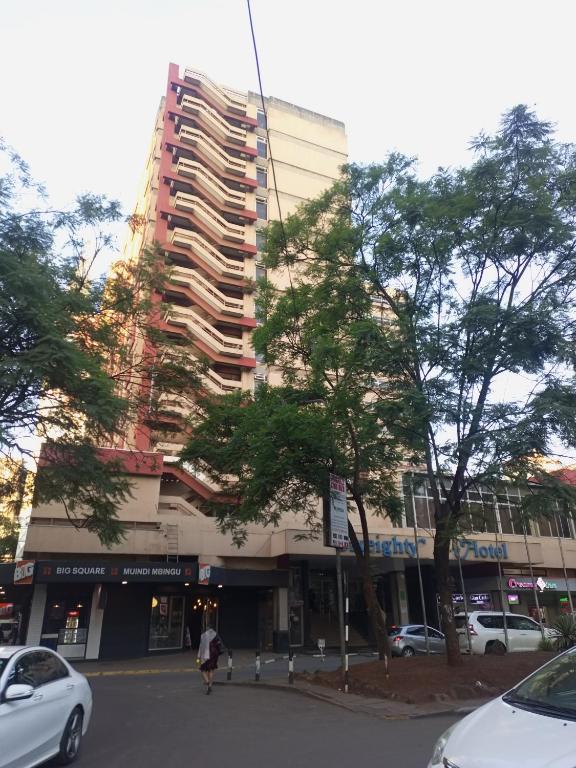 um grande edifício numa rua com carros estacionados na frente em MAANZONI 680 HOTEL em Nairobi