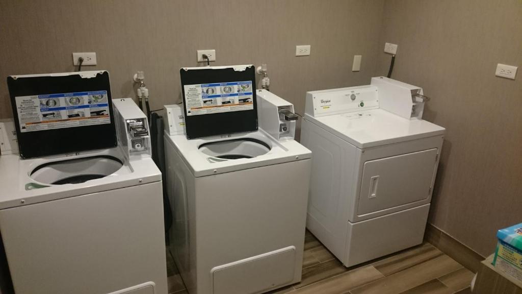 a laundry room with three machines and a washer and dryer at Grace Hotel in Zhonghe