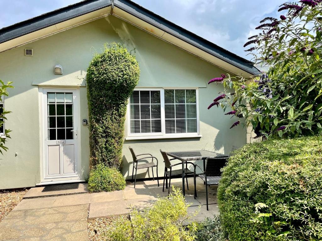 ein Tisch und Stühle vor einem Haus in der Unterkunft Seagull Leigh Cottages in Seaton