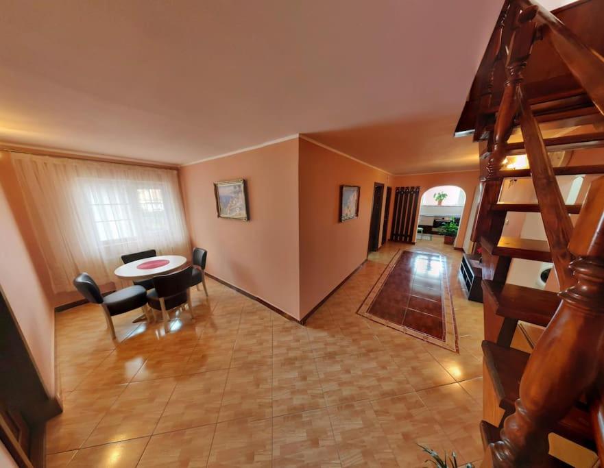ein Wohnzimmer mit einer Treppe, einem Tisch und Stühlen in der Unterkunft Modern 3-bedroom place in Ramnicu Valcea in Râmnicu Vâlcea