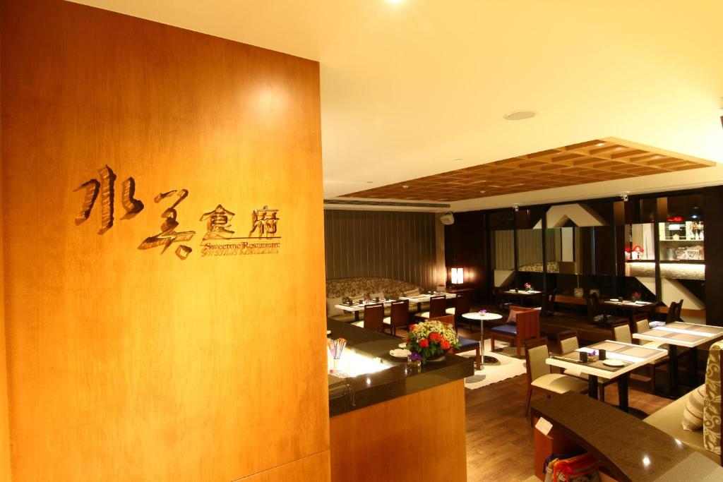 a restaurant with tables and chairs and a sign on the wall at Beitou Sweet Me Hot Spring Resort in Taipei