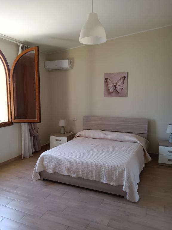 a bedroom with a bed with a butterfly picture on the wall at Luminoso Appartamento con Terrazza......C.U......Q2483 in Sìnnai
