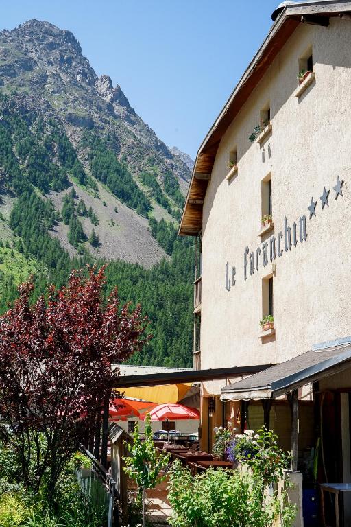 a building with a sign on it with a mountain at Hotel Le Faranchin in Villar-dʼArène