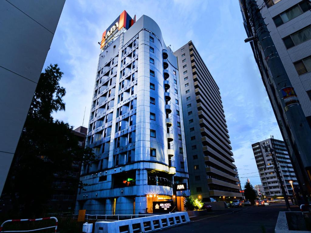 a tall building with a sign on top of it at APA Hotel Sapporo Hosui Susukino Ekimae in Sapporo