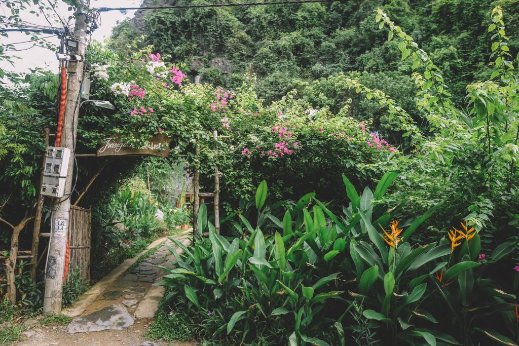 a garden with plants and flowers on a path at Trang An Ecolodge in Ninh Binh