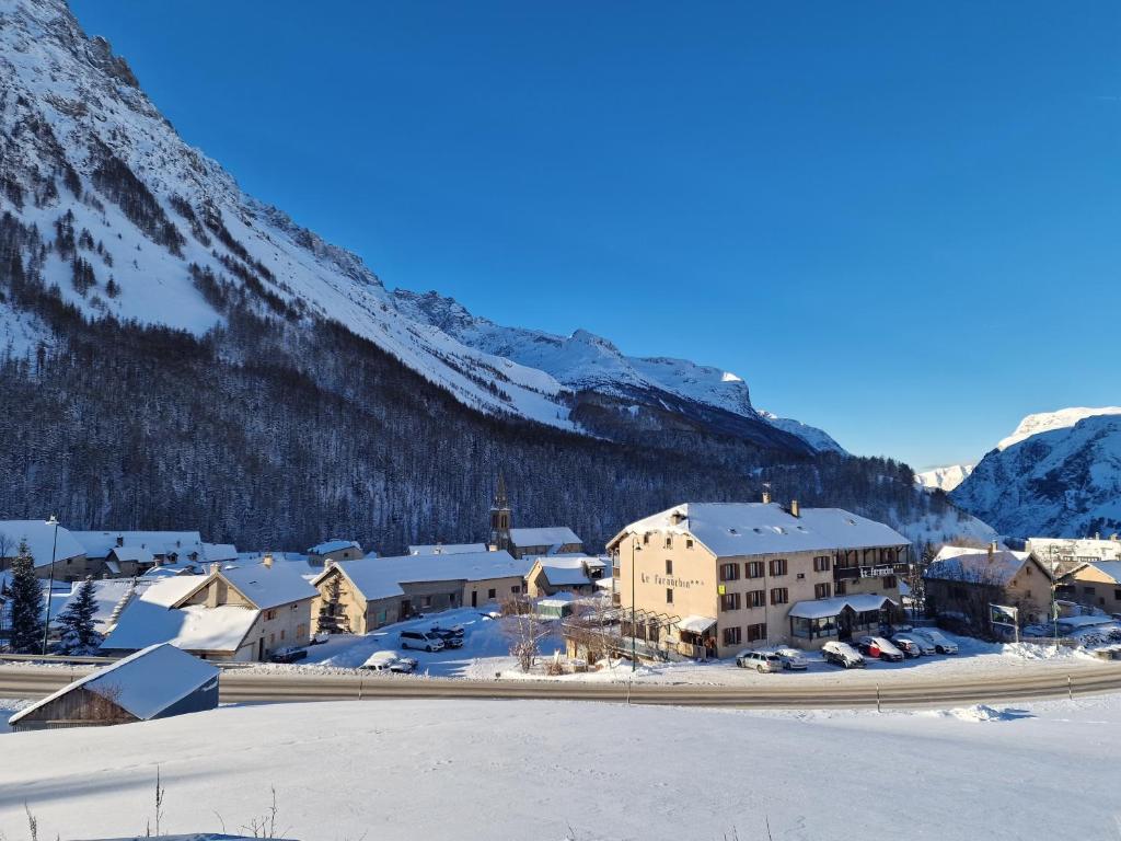 a town in the snow with a mountain at Hotel Le Faranchin in Villar-dʼArène