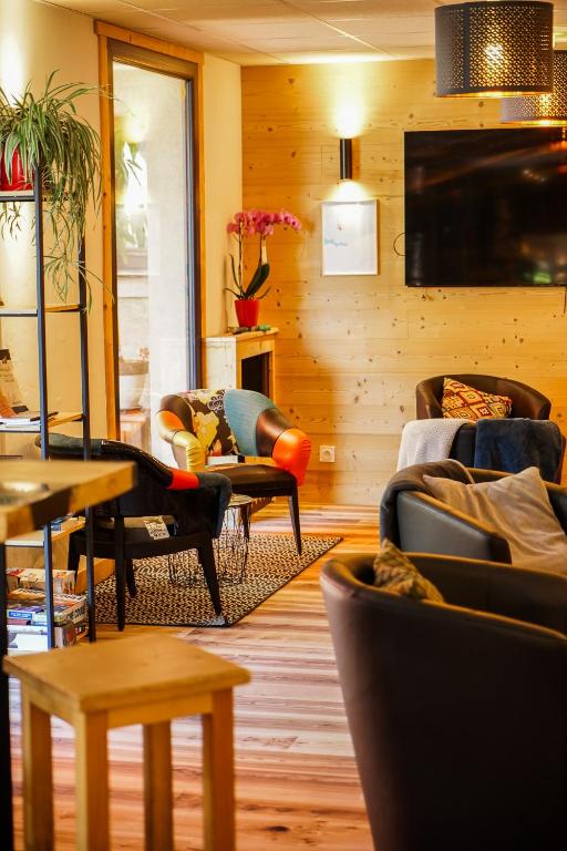 a living room with couches and chairs and a television at Hotel Le Faranchin in Villar-dʼArène