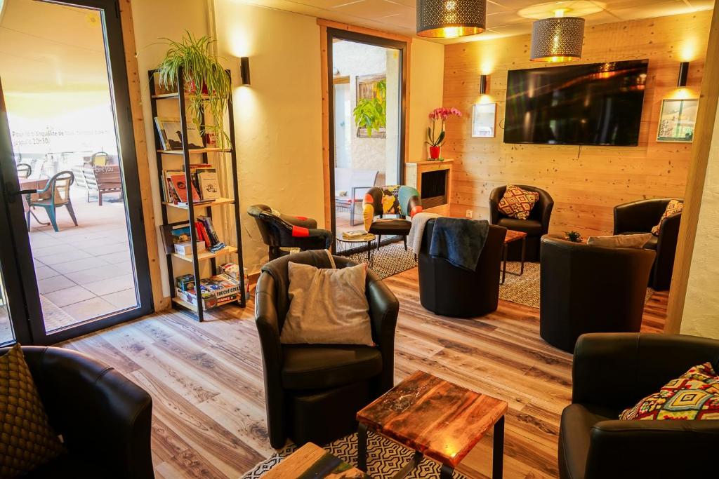 a waiting room with couches and chairs and a table at Hotel Le Faranchin in Villar-dʼArène