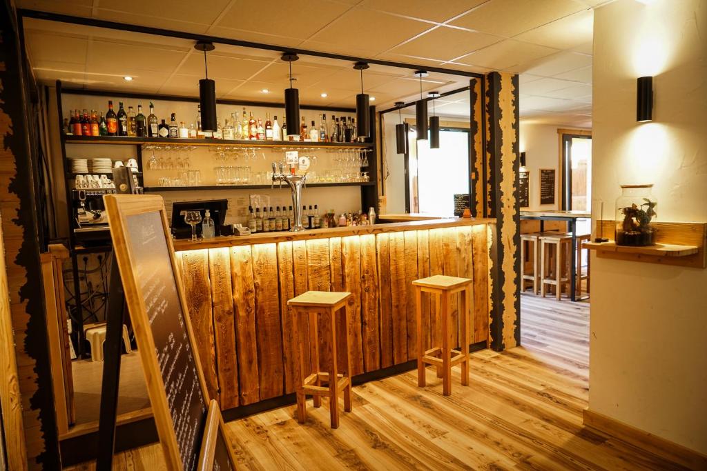 a bar with two stools in a room at Hotel Le Faranchin in Villar-dʼArène