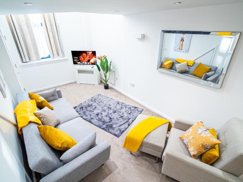 ein Wohnzimmer mit Sofa und gelben Kissen in der Unterkunft Stylish Spacious 1 Bedroom Apt At Dealhouse in Huddersfield
