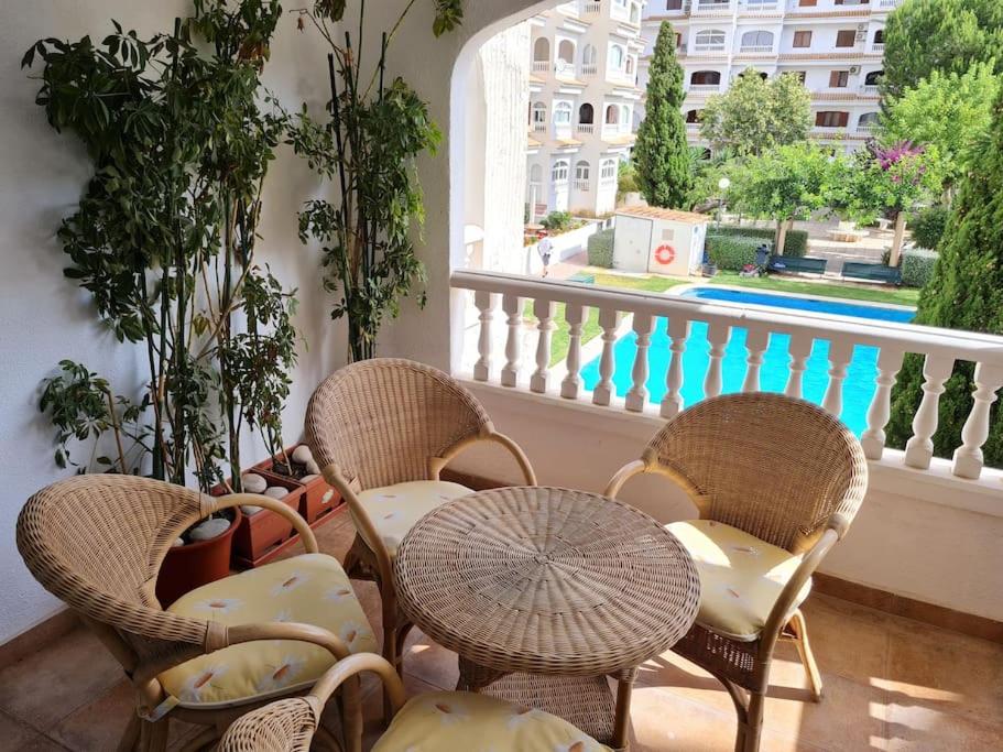 een groep stoelen en tafels op een balkon bij Nice and cozy flat with pool next to the beach in Albir