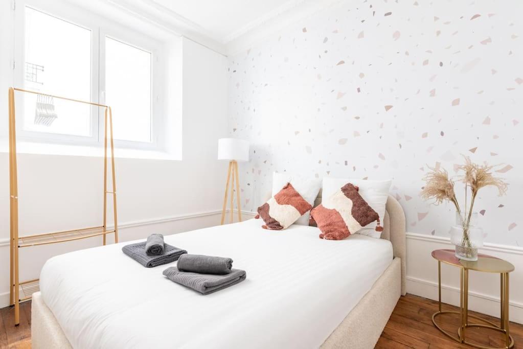 - une chambre blanche avec un lit blanc et des oreillers dans l'établissement Appartement proche Montparnasse - Jungle - II, à Paris