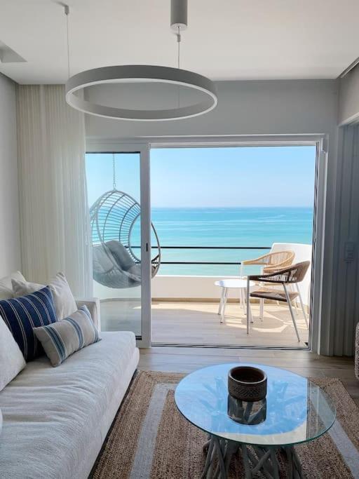 a living room with a couch and a view of the ocean at Front Sea Apartment Albufeira in Albufeira