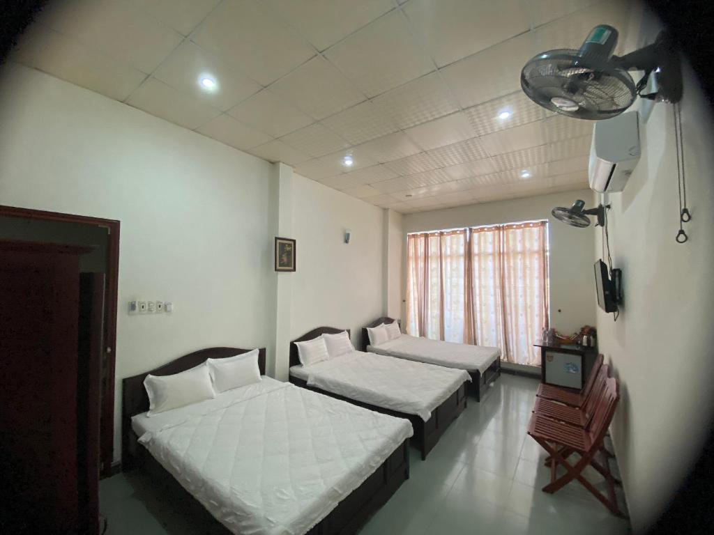 um quarto com duas camas e uma televisão em Hotel Cát Tường em La Gi