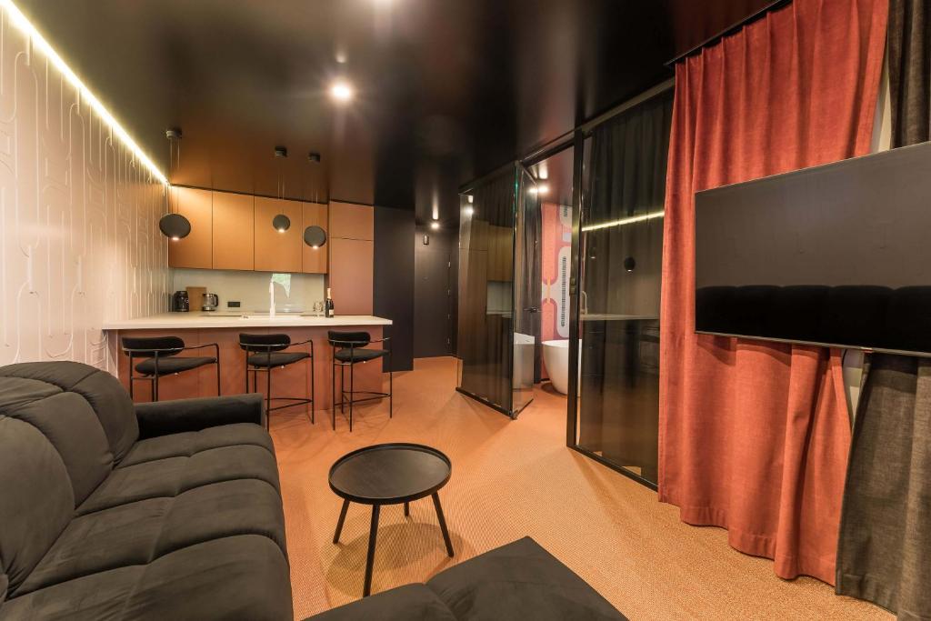 ein Wohnzimmer mit Couch und Fernseher und eine Küche in der Unterkunft Salt Island Apartments in Kołobrzeg