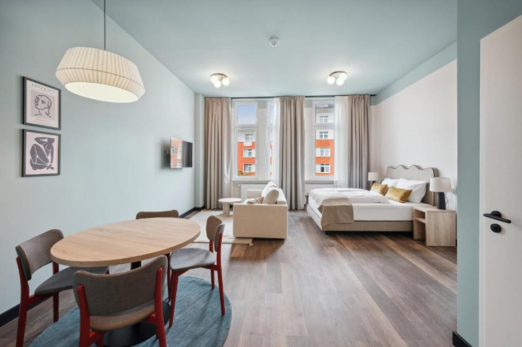 een woonkamer met een tafel en een bed bij limehome Berlin Stresemannstr in Berlijn