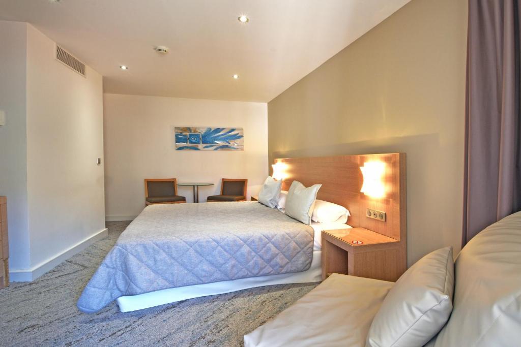 Postel nebo postele na pokoji v ubytování Hôtel Le Rocher