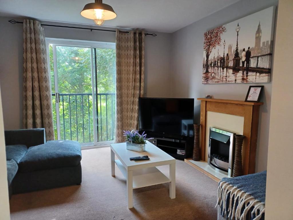 a living room with a couch and a tv at Huku Kwetu -The Maltings White Door-1st Floor-2 Bedroom Apartment -Self Catering-Quiet- Free Parking in Dunstable