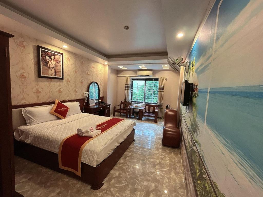 a bedroom with a bed and a desk and a room at Khách Sạn Nam Sơn in Ðông Khê