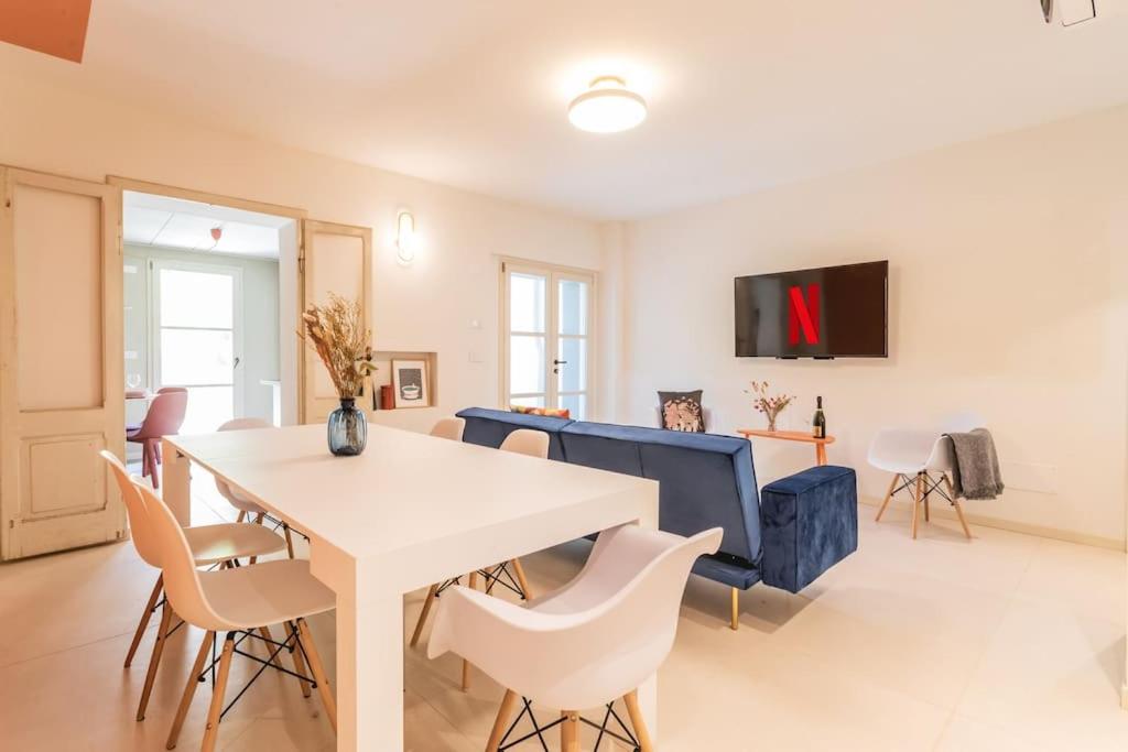 ein Wohnzimmer mit einem weißen Tisch und Stühlen in der Unterkunft Luxury & Design: Oasi nel centro storico di Rimini in Rimini