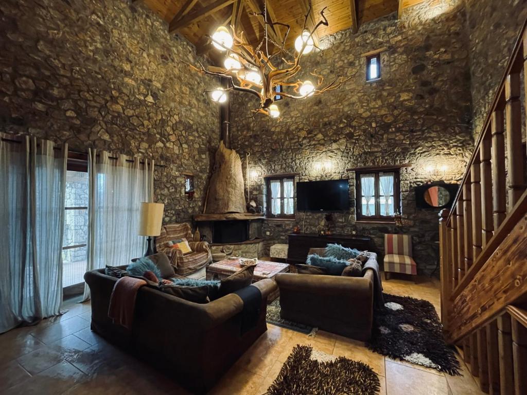a living room with couches and a stone wall at Country Stone House ,next to Kalavrita in Kalavrita