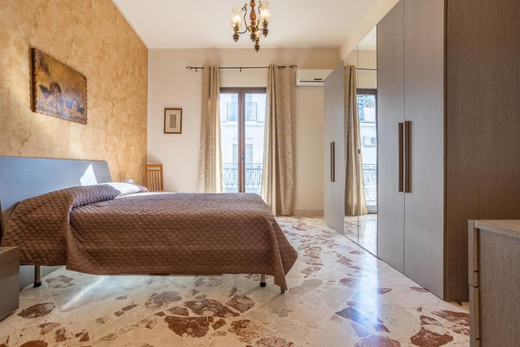 1 dormitorio con cama y lámpara de araña en Casa A Cinisi Vicino Al Centro, en Cinisi