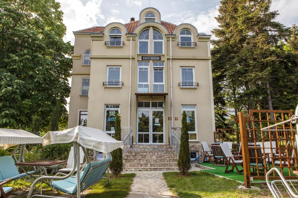 a building with chairs and tables in front of it at Hotel Duchess in Varna City