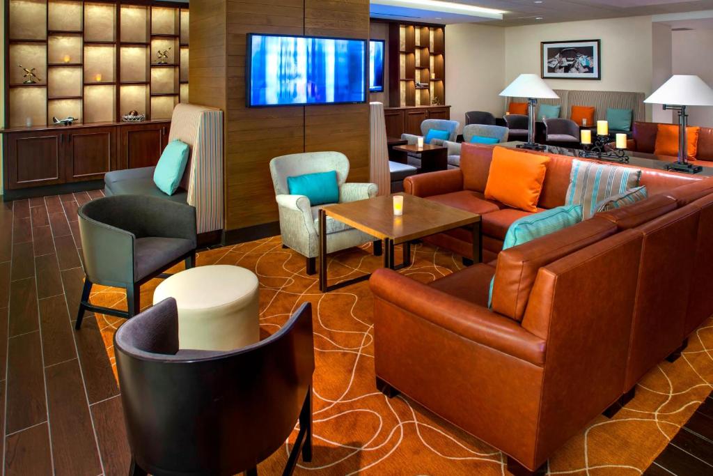 a hotel lobby with furniture and a flat screen tv at Newark Liberty International Airport Marriott in Newark