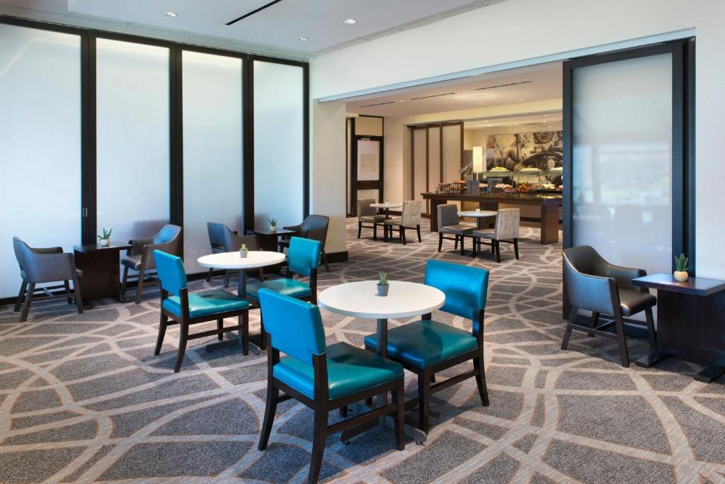 a dining room with tables and chairs and windows at Newark Liberty International Airport Marriott in Newark