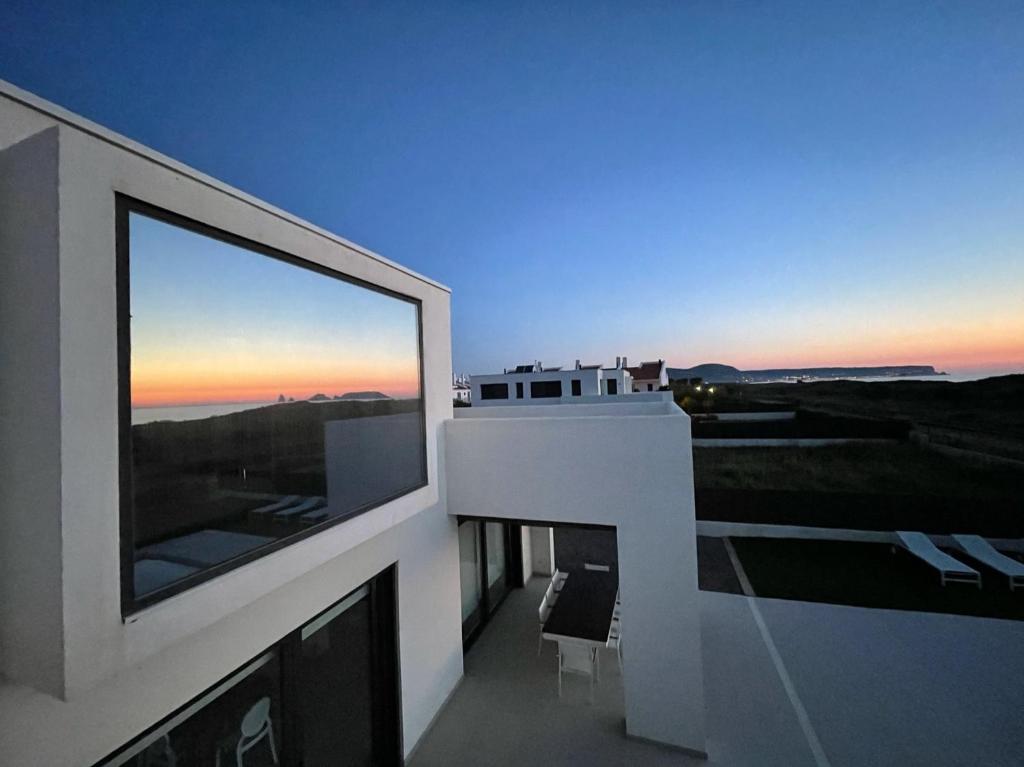 einen Balkon eines Gebäudes mit Blick auf den Sonnenuntergang in der Unterkunft VILLA PINELL in Torroella de Montgrí