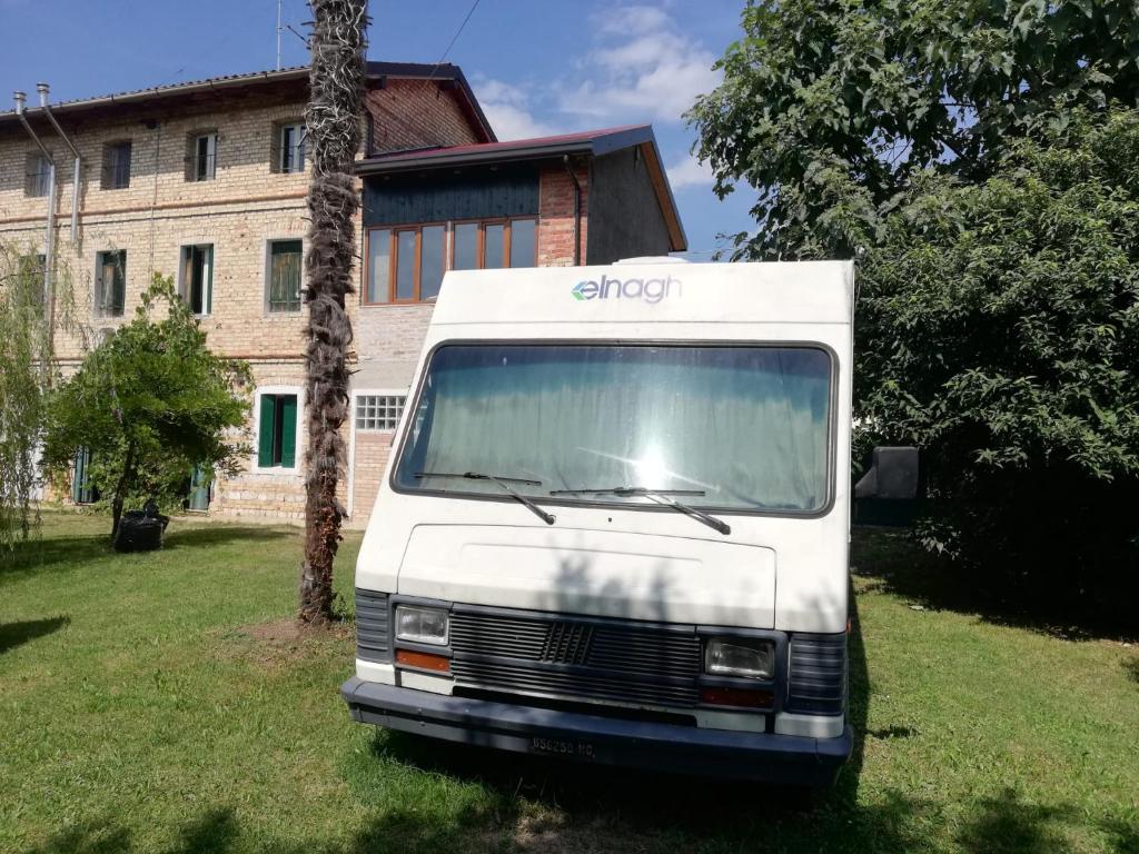 una furgoneta blanca estacionada frente a un edificio en Il Camper di Ermione en Cordenons