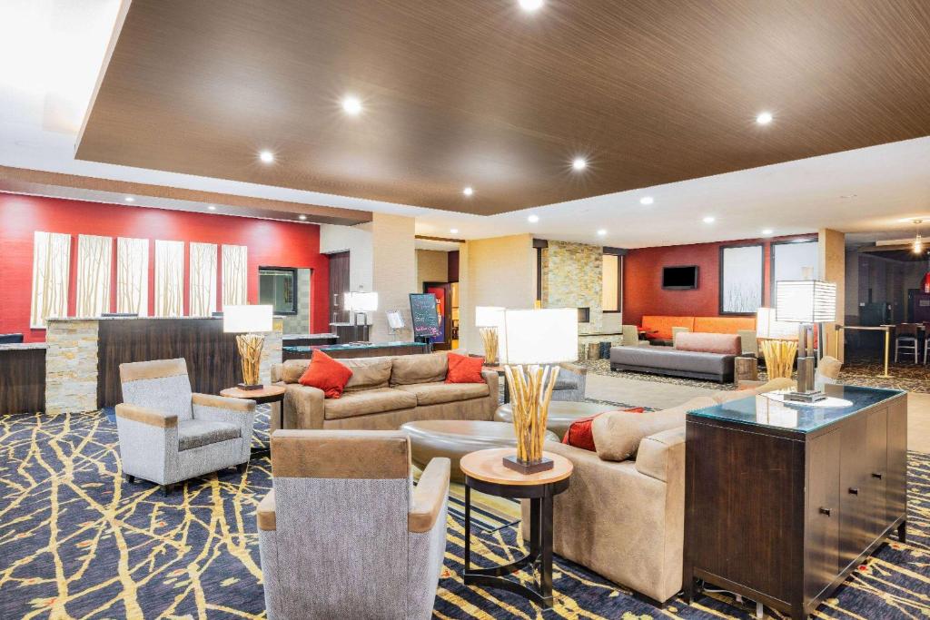 Un vestíbulo de hotel con sofás, mesas y sillas. en Ramada by Wyndham Grand Forks, en Grand Forks