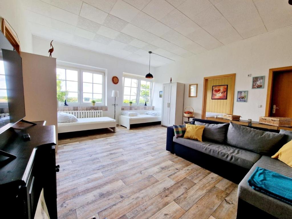 sala de estar con sofá negro y suelo de madera en 2-Zimmer-Apartment für 4 PersonenFeWo 1, 