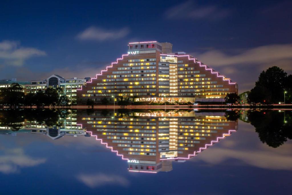 un bâtiment avec sa réflexion dans l'eau la nuit dans l'établissement Hyatt Regency Boston/Cambridge, à Cambridge