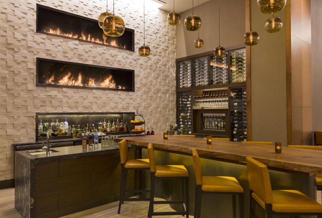 a bar with yellow chairs and a fireplace at Grand Hyatt Denver in Denver