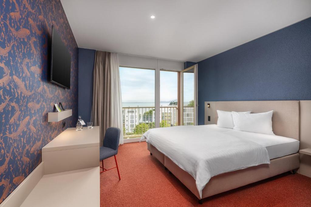 ein Hotelzimmer mit einem Bett und einem Fenster in der Unterkunft b-smart hotel Arbon in Arbon