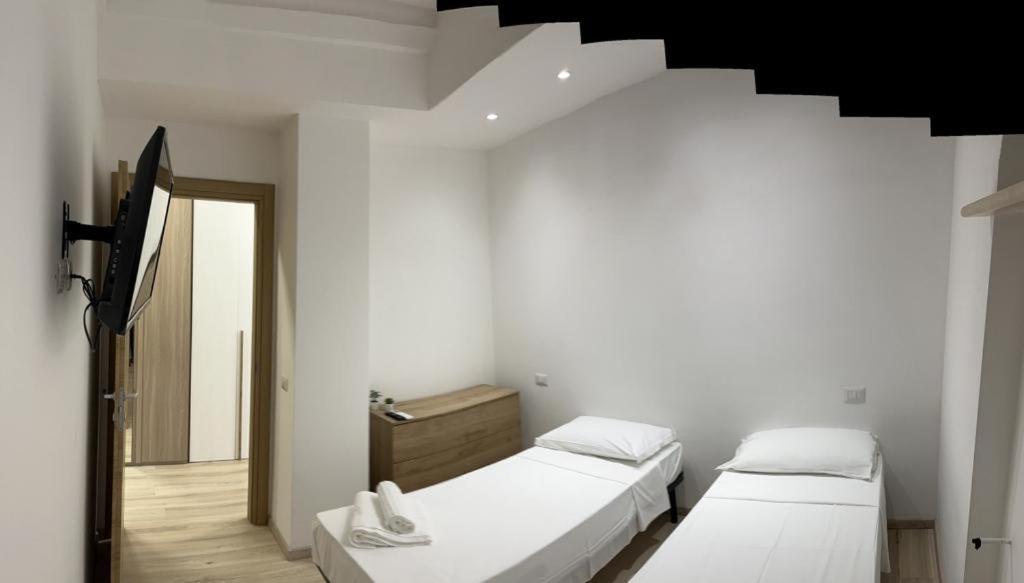 two beds in a white room with a staircase at Villa Milano Apt. n. 1 in Milan