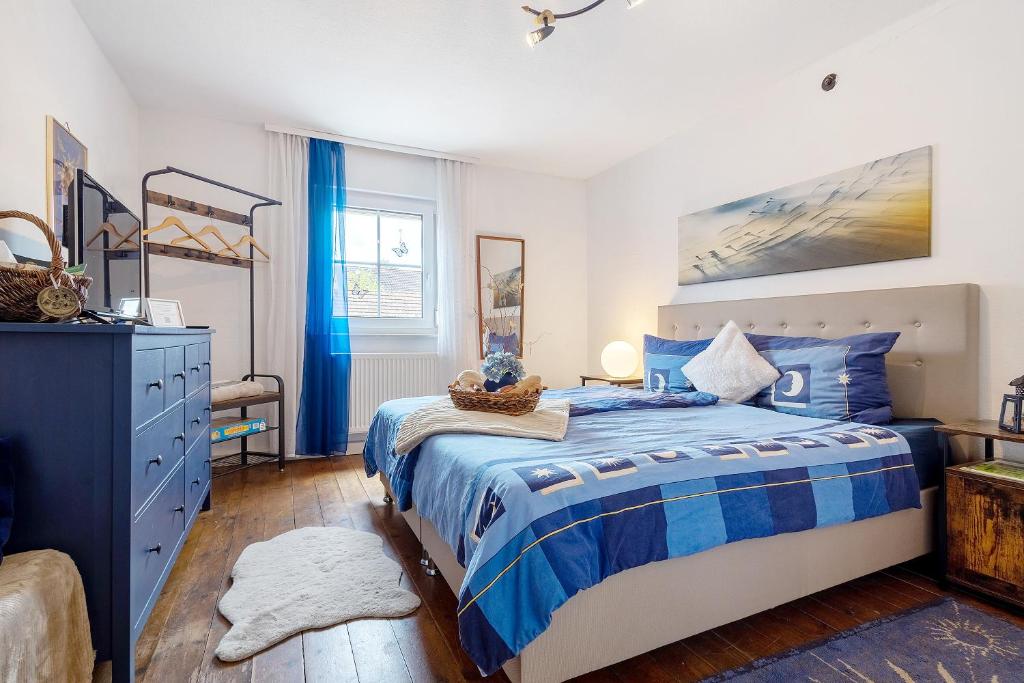 Un dormitorio con una cama azul y blanca y un tocador en Lindenhardt, en Creußen