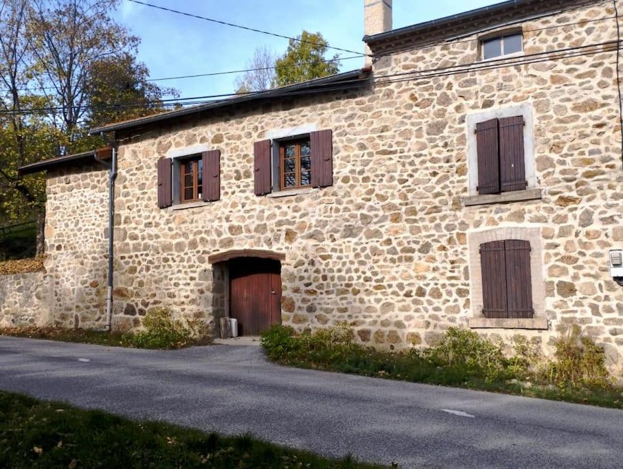 an old stone building with brown shuttered windows at Maison de vacances en Ardèche in Pailharès