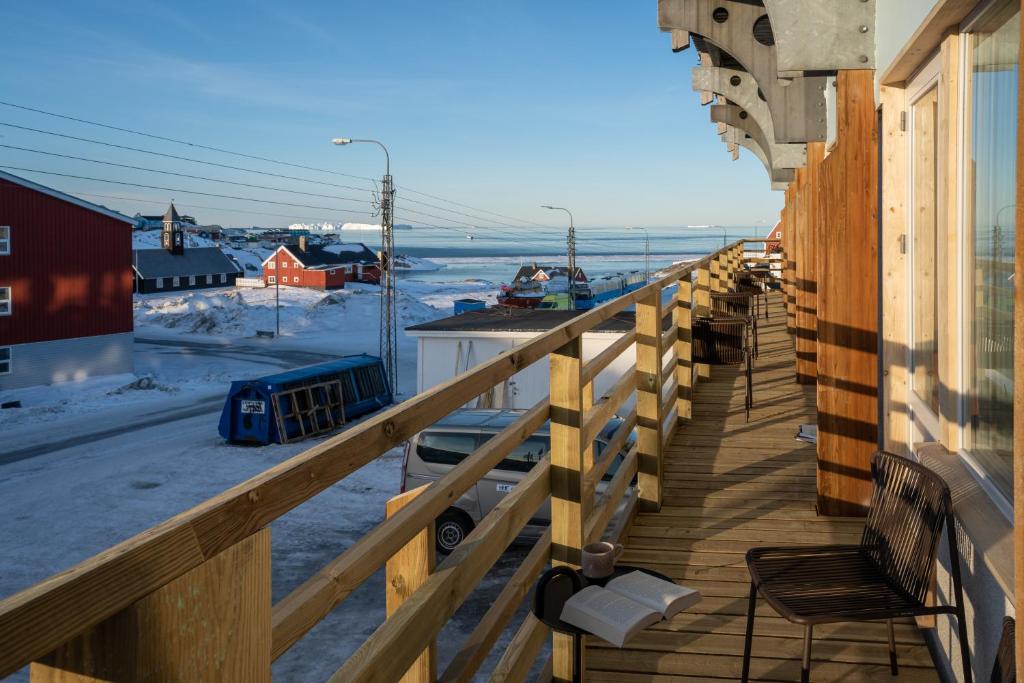 a balcony of a house with a view of the ocean at Hotel Hvide Falk in Ilulissat